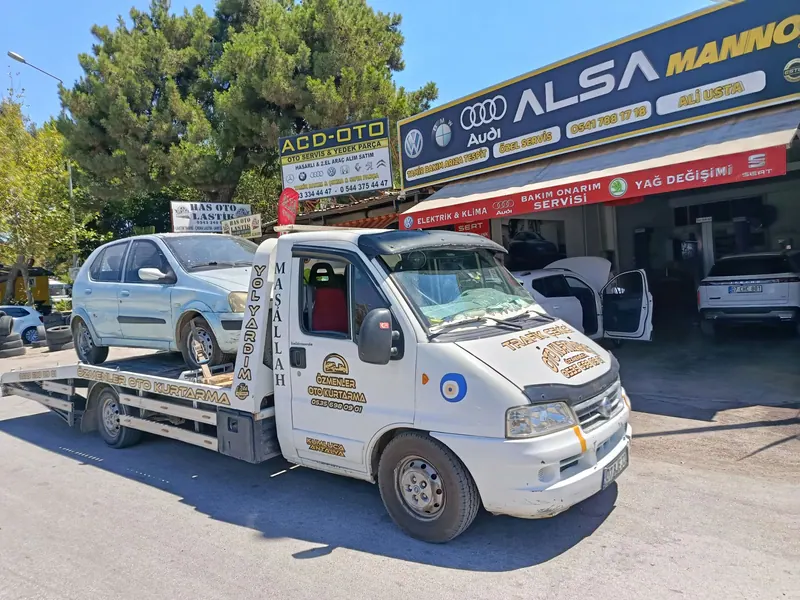 Özmenler Oto Kurtarıcı çekicisi açık renk otomobili servis önünde taşırken
